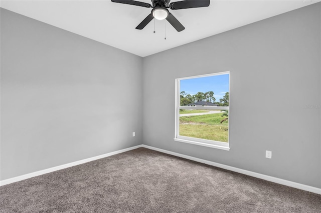 carpeted spare room featuring ceiling fan