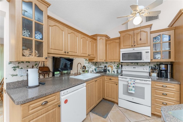 kitchen featuring vaulted ceiling, white appliances, light tile patterned floors, ceiling fan, and sink