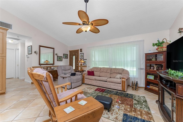 living room featuring ceiling fan, light tile patterned floors, a textured ceiling, and vaulted ceiling