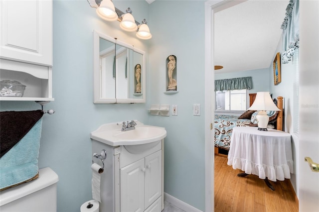 bathroom with hardwood / wood-style flooring, vanity, and toilet