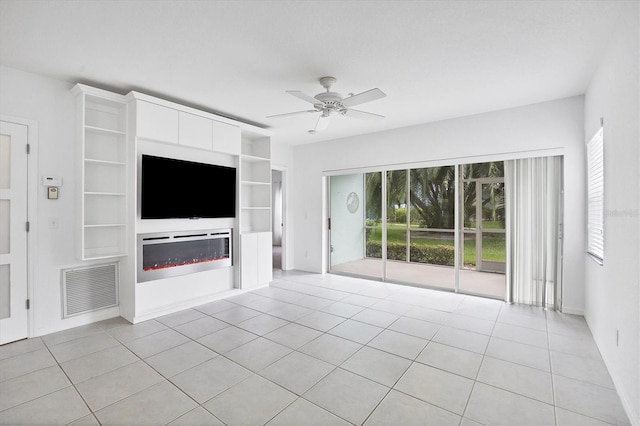 unfurnished living room with built in shelves, ceiling fan, and light tile patterned floors