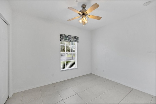 tiled empty room featuring ceiling fan