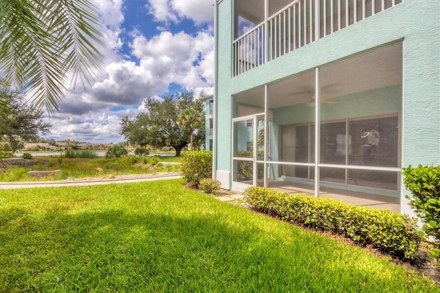 view of yard with a balcony and a sunroom