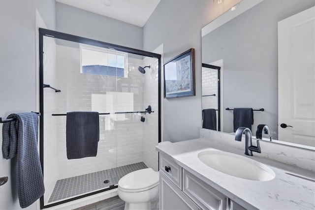 bathroom with wood-type flooring, vanity, toilet, and an enclosed shower