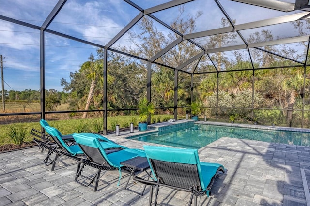 view of pool featuring glass enclosure and a patio area