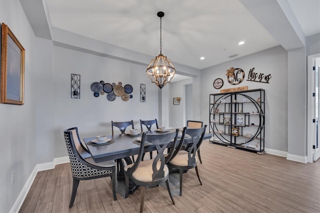 dining room with light wood-type flooring and a chandelier