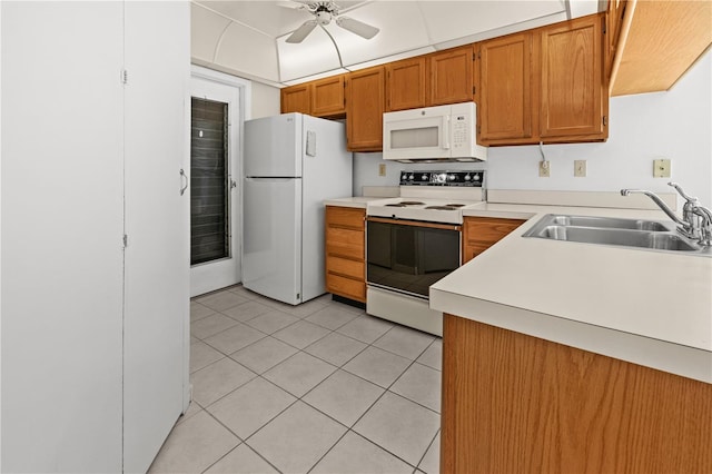 kitchen with light tile patterned flooring, white appliances, ceiling fan, and sink