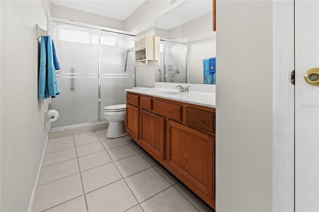 bathroom featuring tile patterned floors, vanity, a shower with shower door, and toilet