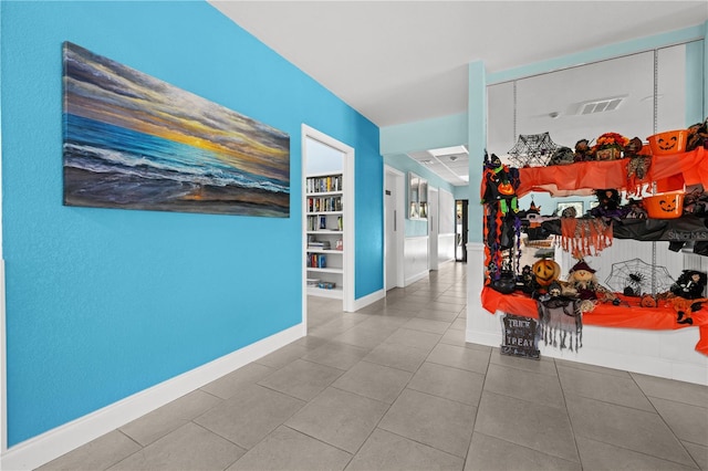 corridor with tile patterned flooring and built in shelves