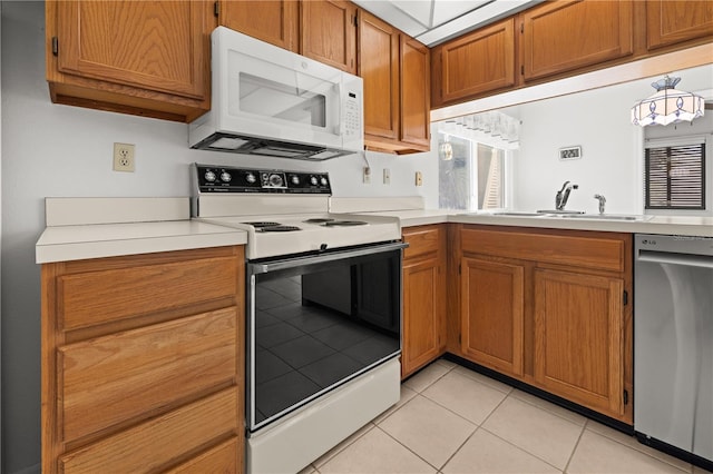 kitchen with sink, light tile patterned floors, and white appliances