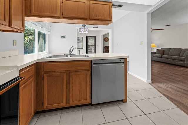 kitchen featuring white range, sink, stainless steel dishwasher, light wood-type flooring, and kitchen peninsula