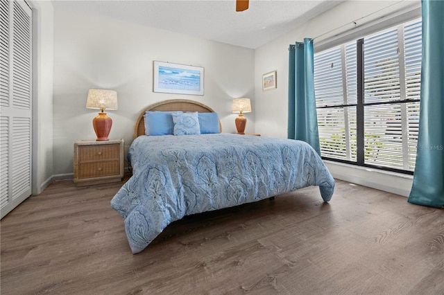 bedroom featuring hardwood / wood-style floors, a textured ceiling, a closet, and ceiling fan