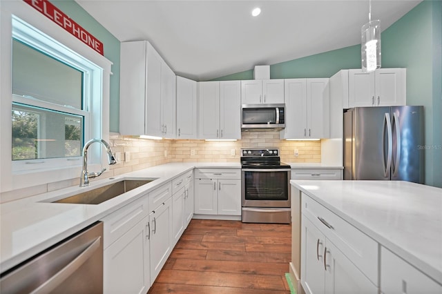 kitchen with white cabinets, lofted ceiling, sink, dark wood-type flooring, and stainless steel appliances