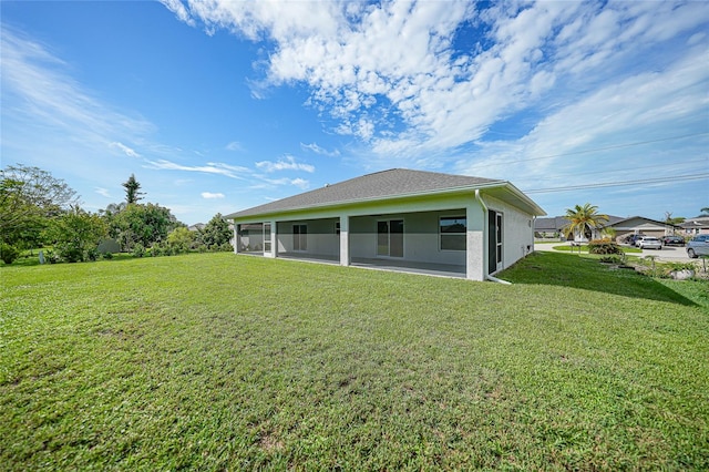 rear view of property with a lawn and a sunroom