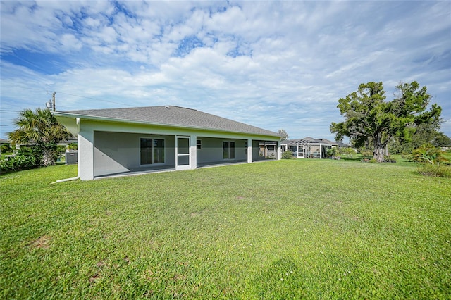 back of house with a lawn and glass enclosure