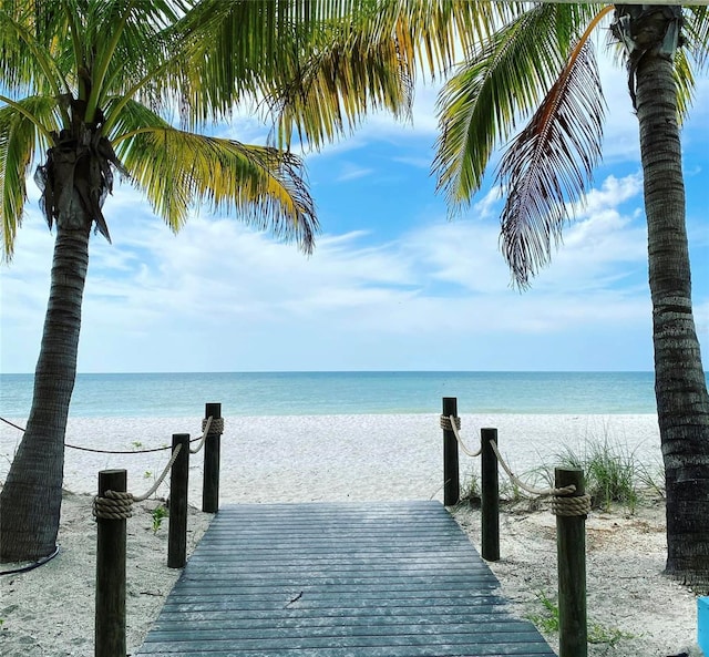 view of dock featuring a view of the beach and a water view