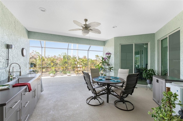 view of patio / terrace with a lanai, sink, and ceiling fan