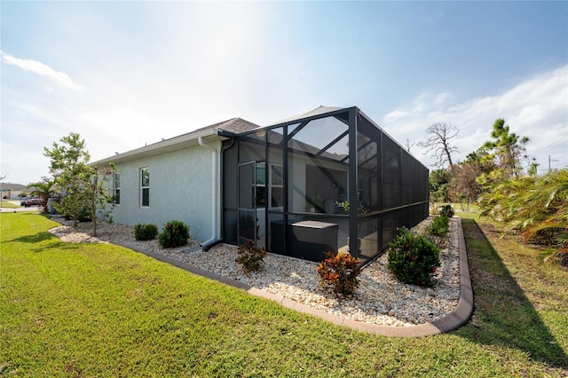 view of side of property featuring glass enclosure and a lawn