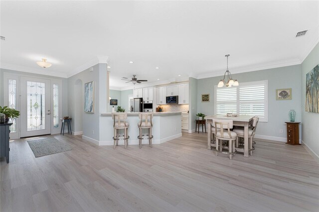 552 Box Elder Ct, Englewood, FL 34223 - dining space with light wood-type flooring, baseboards, and ornamental molding
