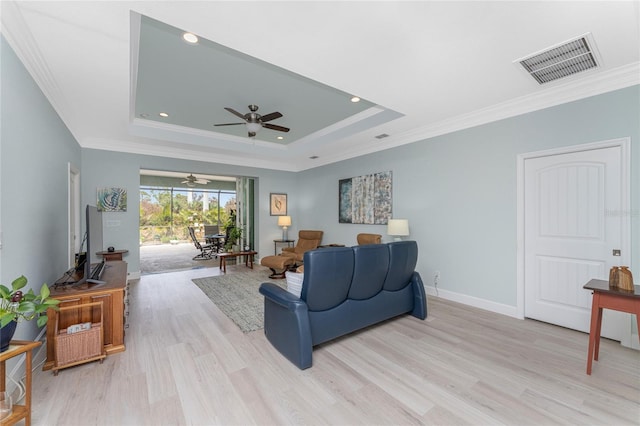 552 Box Elder Ct, Englewood, FL 34223 - living area featuring a tray ceiling, crown molding, visible vents, and light wood finished floors