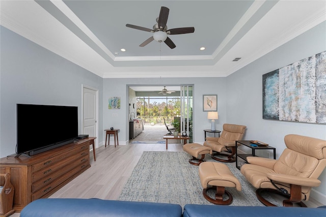 552 Box Elder Ct, Englewood, FL 34223 - living area featuring visible vents, ornamental molding, baseboards, light wood-style floors, and a raised ceiling