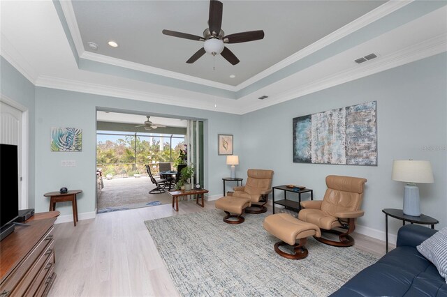 552 Box Elder Ct, Englewood, FL 34223 - living area with wood finished floors, visible vents, baseboards, a tray ceiling, and ornamental molding
