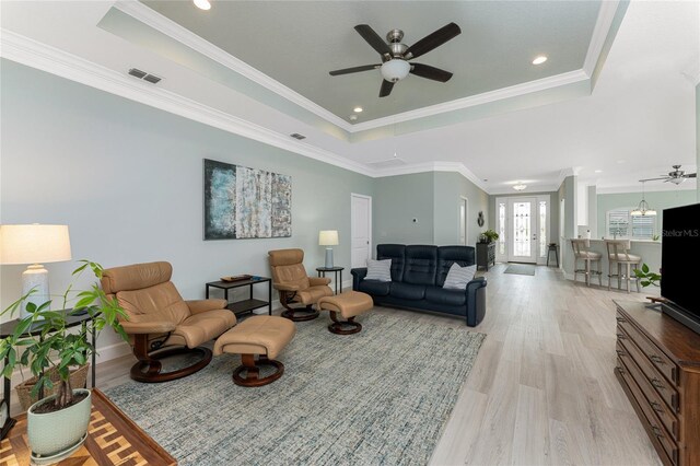 552 Box Elder Ct, Englewood, FL 34223 - living room featuring light wood finished floors, visible vents, crown molding, and a raised ceiling
