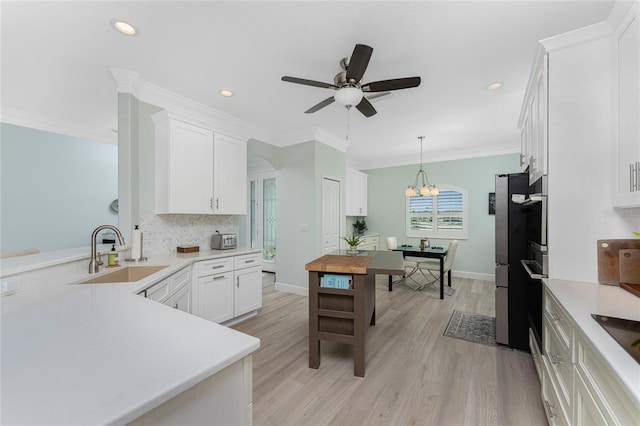 552 Box Elder Ct, Englewood, FL 34223 - kitchen with decorative backsplash, light countertops, crown molding, and a sink