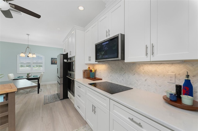 552 Box Elder Ct, Englewood, FL 34223 - kitchen with tasteful backsplash, crown molding, light countertops, stainless steel appliances, and white cabinetry
