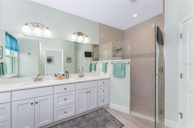 552 Box Elder Ct, Englewood, FL 34223 - full bathroom featuring double vanity, a shower stall, wood finished floors, and a sink