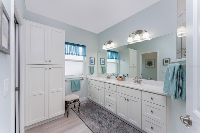 552 Box Elder Ct, Englewood, FL 34223 - full bath with double vanity, wood finished floors, baseboards, and a sink
