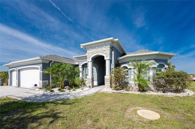 14344 Amestoy Ave, Port Charlotte, FL 33981 - mediterranean / spanish home featuring a front yard, stone siding, a garage, stucco siding, and driveway