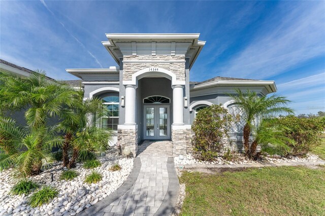 14344 Amestoy Ave, Port Charlotte, FL 33981 - entrance to property featuring french doors, stone siding, and stucco siding