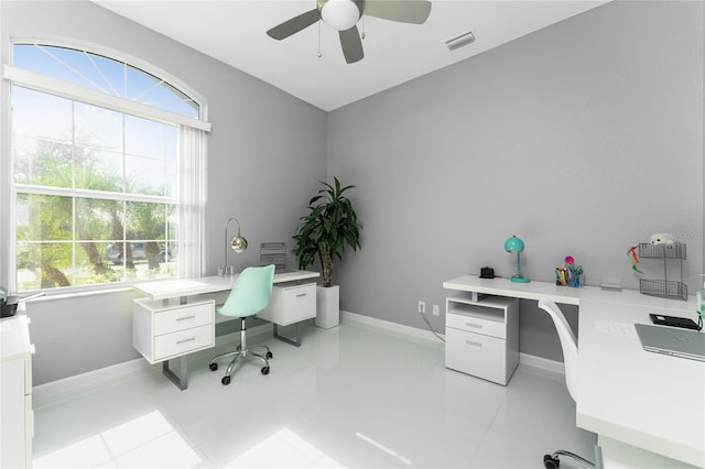 tiled home office featuring ceiling fan and a wealth of natural light