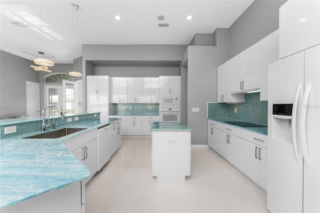 kitchen with white cabinets, hanging light fixtures, sink, white appliances, and a center island