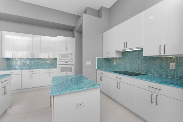 14344 Amestoy Ave, Port Charlotte, FL 33981 - kitchen featuring light tile patterned floors, white appliances, under cabinet range hood, decorative backsplash, and a kitchen island
