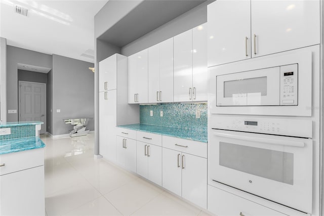 14344 Amestoy Ave, Port Charlotte, FL 33981 - kitchen featuring tasteful backsplash, visible vents, baseboards, white appliances, and white cabinetry