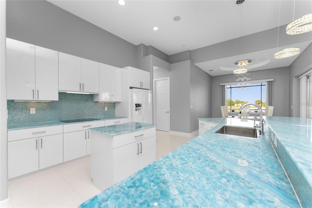 14344 Amestoy Ave, Port Charlotte, FL 33981 - kitchen with white fridge with ice dispenser, white cabinets, black electric cooktop, a sink, and hanging light fixtures