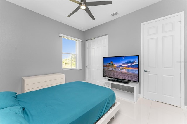 tiled bedroom featuring ceiling fan and a closet