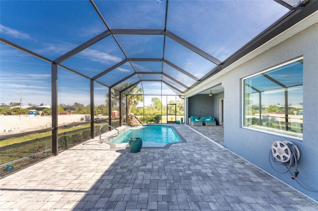 view of pool with glass enclosure and a patio