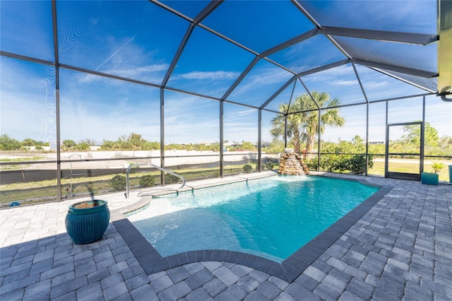 view of pool with a lanai, pool water feature, and a patio area