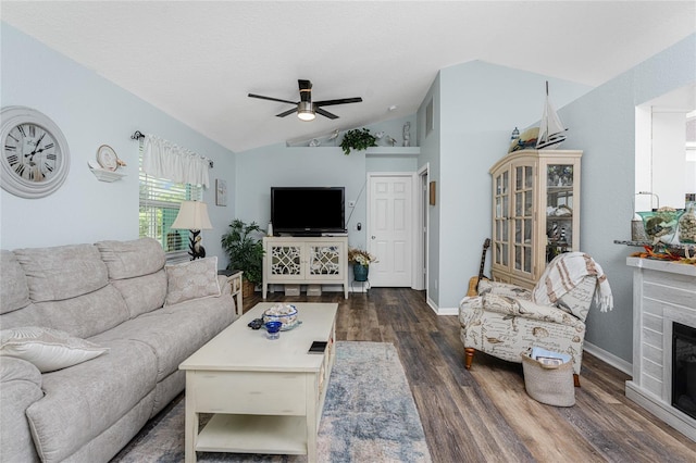 living room with ceiling fan, dark hardwood / wood-style floors, and vaulted ceiling