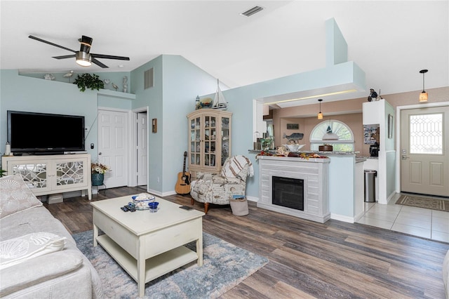 living room featuring ceiling fan, hardwood / wood-style flooring, and high vaulted ceiling