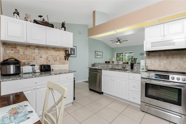 kitchen with sink, appliances with stainless steel finishes, vaulted ceiling, and decorative backsplash