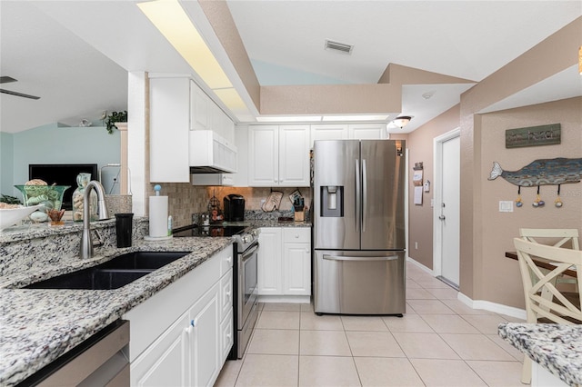 kitchen featuring sink, white cabinetry, stainless steel appliances, light stone countertops, and vaulted ceiling