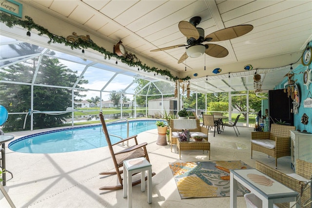 view of swimming pool with ceiling fan, a patio, and a lanai