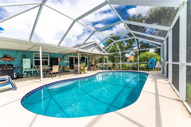 view of swimming pool featuring a patio and glass enclosure