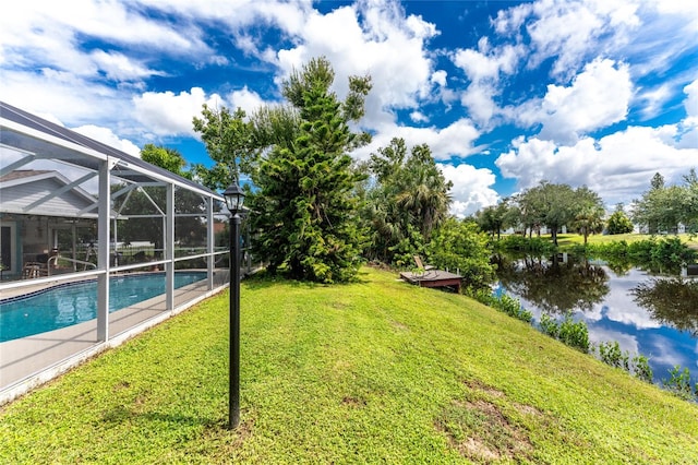 view of yard with a water view and a lanai