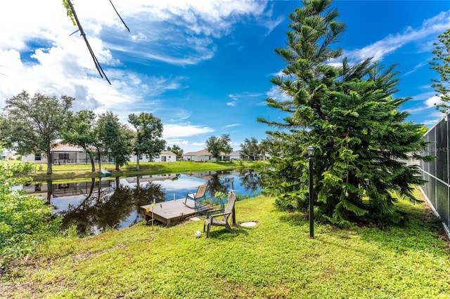 dock area featuring a lawn and a water view