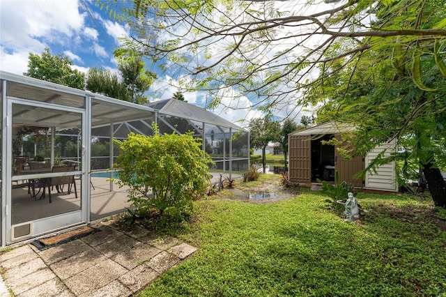 view of yard with glass enclosure and a patio area